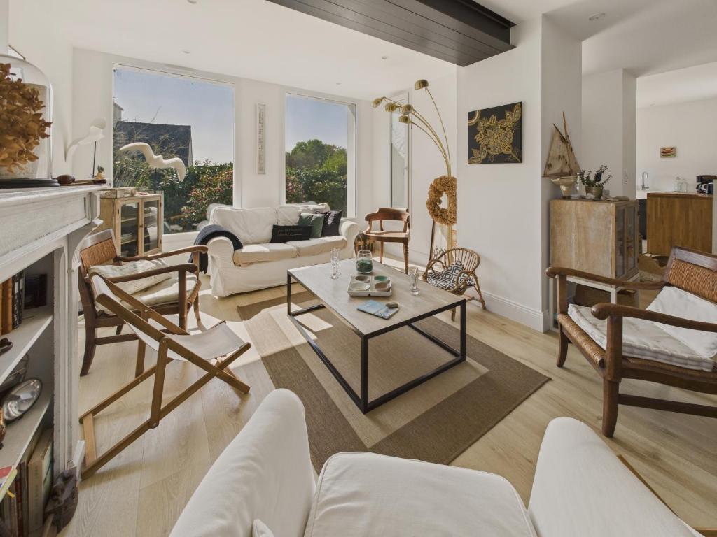 a living room with white furniture and a fireplace at Maison avec jardin pour 4 adultes et 2 enfants in Beg-Meil