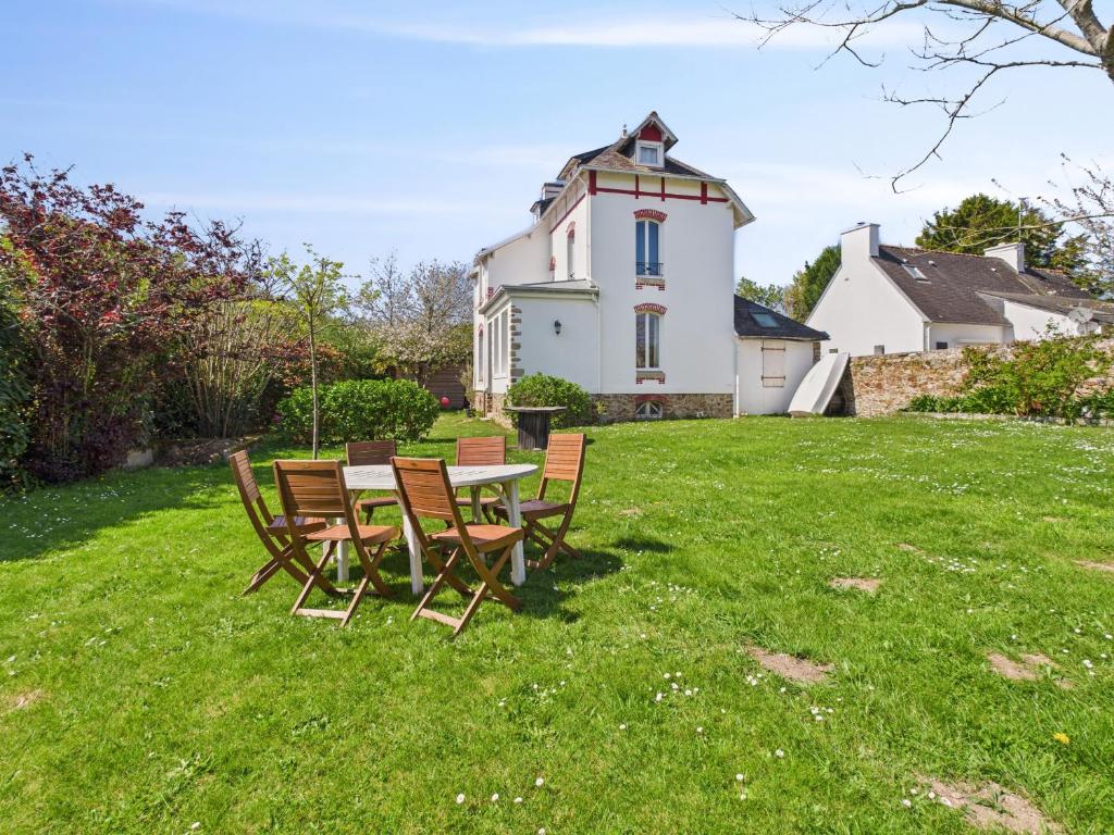 une table et des chaises sur une pelouse devant une maison dans l'établissement Maison avec jardin pour 4 adultes et 2 enfants, à Fouesnant