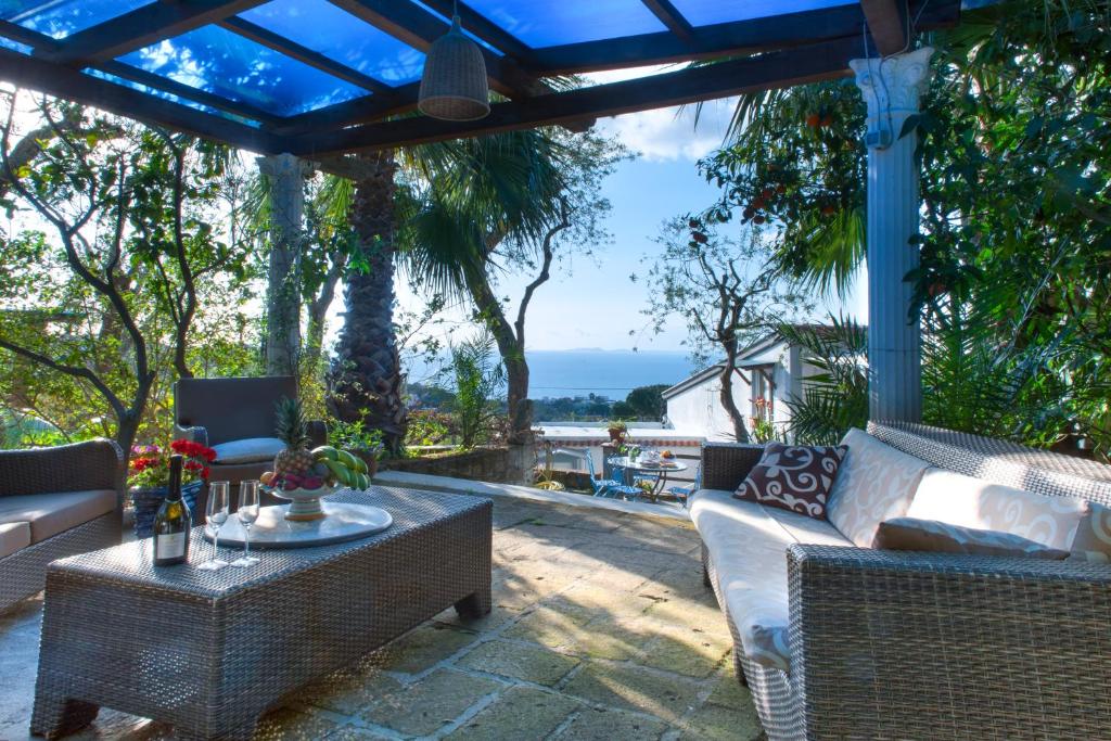 a patio with chairs and a table with a view of the ocean at Villa Giovanna in Sorrento