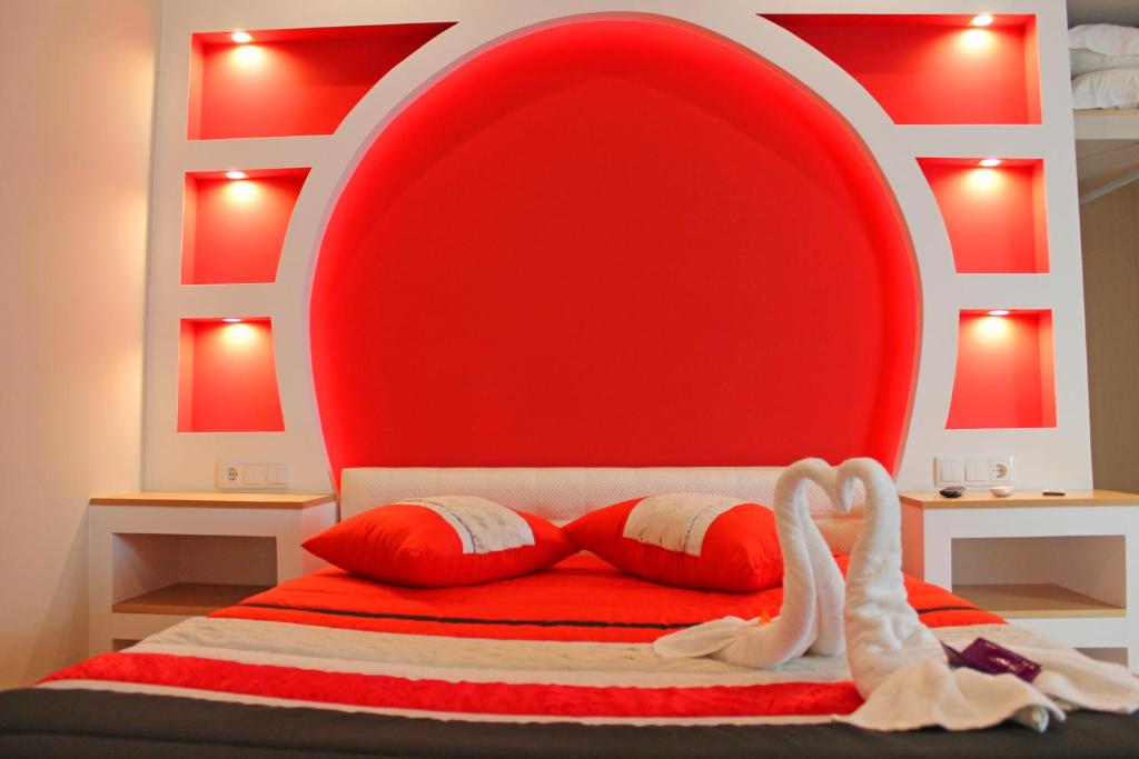 1 cama con cabecero rojo y 2 almohadas en Monte Carlo Love Porto, en Oporto