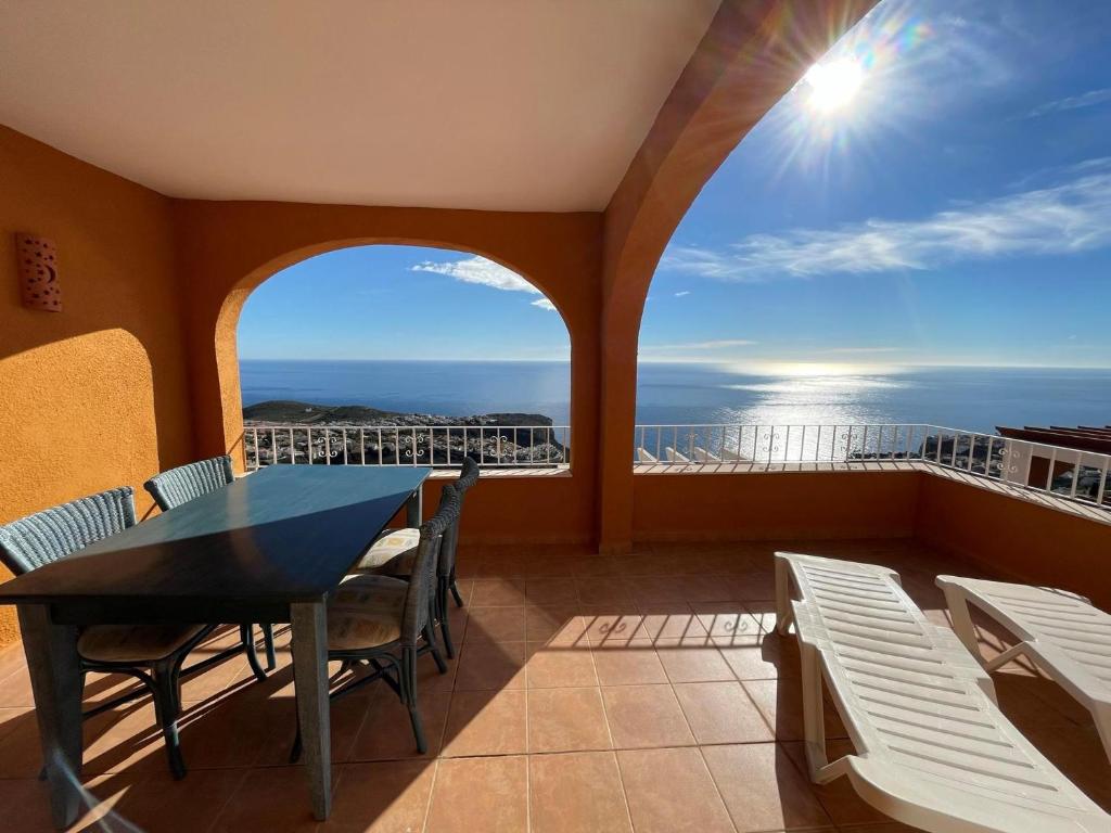 een balkon met een tafel en stoelen en de oceaan bij Atico Vistamar X2113 in Benitachell