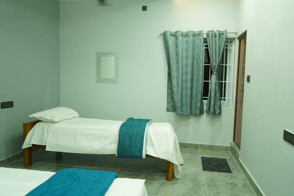 a bedroom with two beds and a window at Babu's Residency WHERE PREMIUM MEETS COST in Tiruvannāmalai