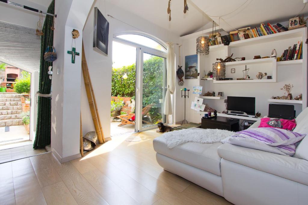 a living room with a white couch and a window at Guest House More in Rijeka