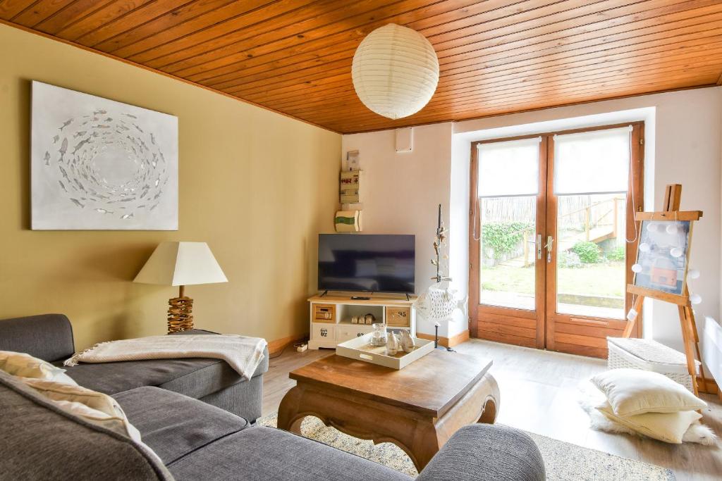 un salon avec un canapé et une télévision dans l'établissement 60 m de la plage - Jardin - Terrasse - Maison pour 5, à La Guérinière