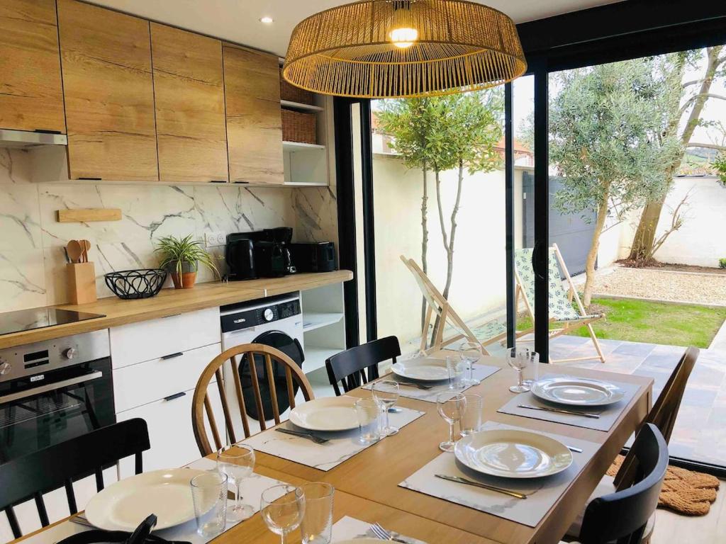 une salle à manger avec une table et des chaises ainsi qu'une cuisine dans l'établissement Séjour à la Mer, à Dives-sur-Mer