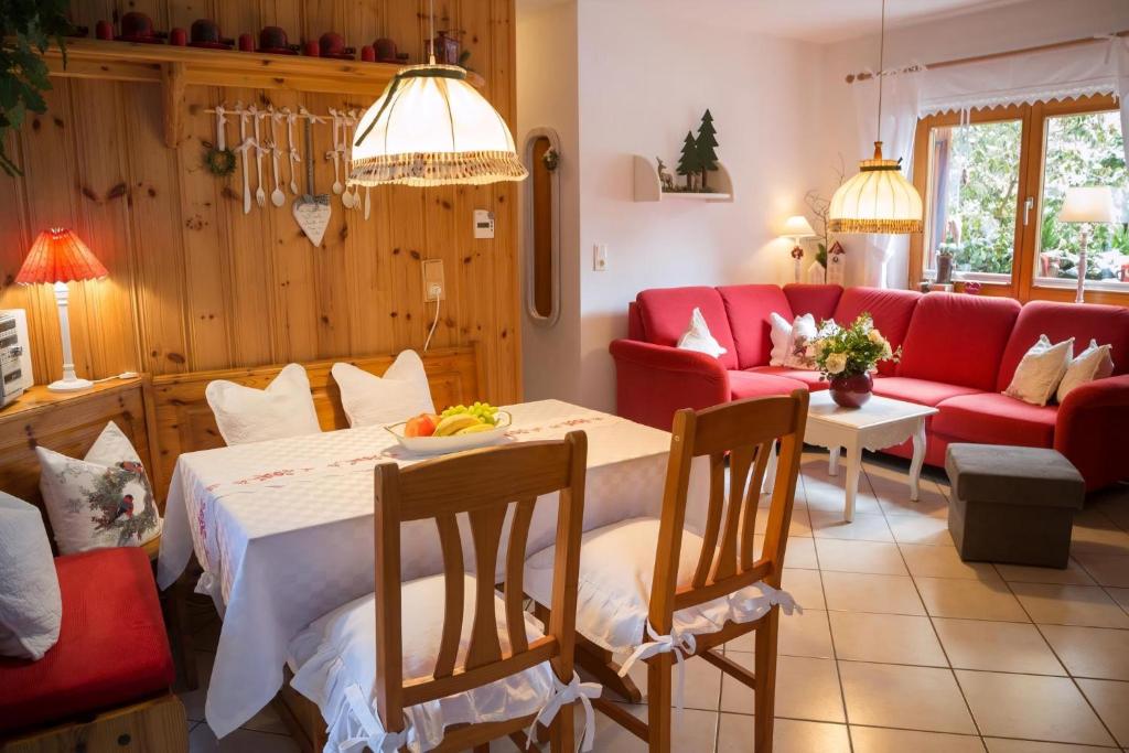 a living room with a table and a red couch at Ferienwohnung In Walkenried Mit Gepflegtem Garten in Walkenried