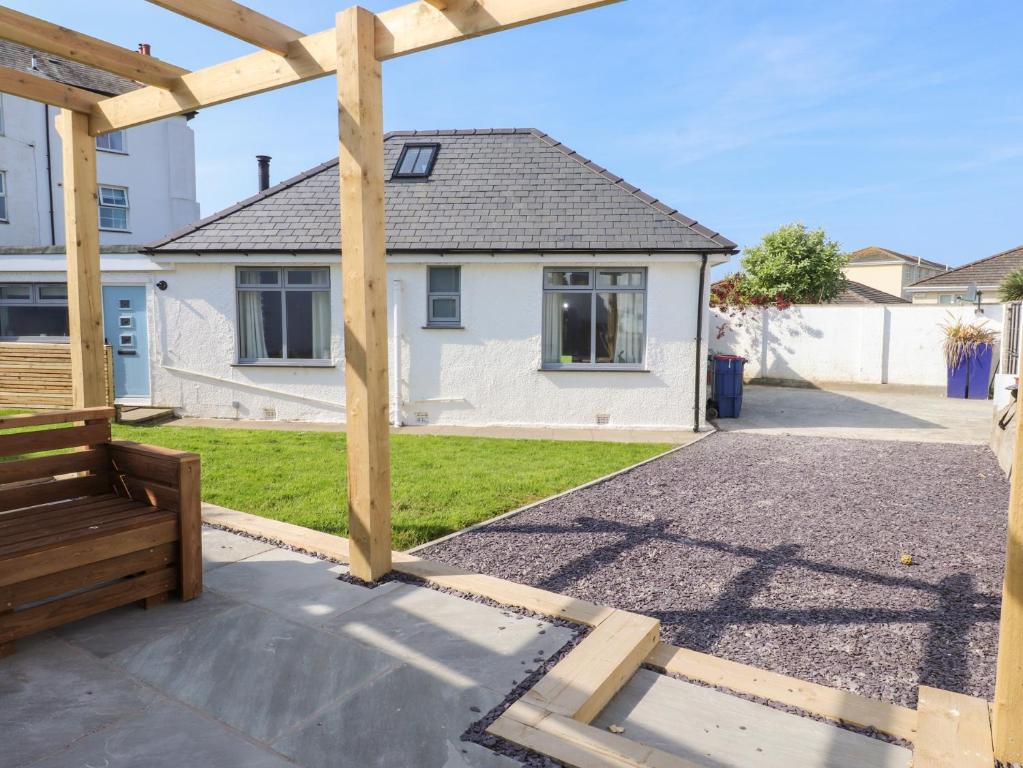 a wooden pergola in front of a house at Trearddur House Cottage in Holyhead