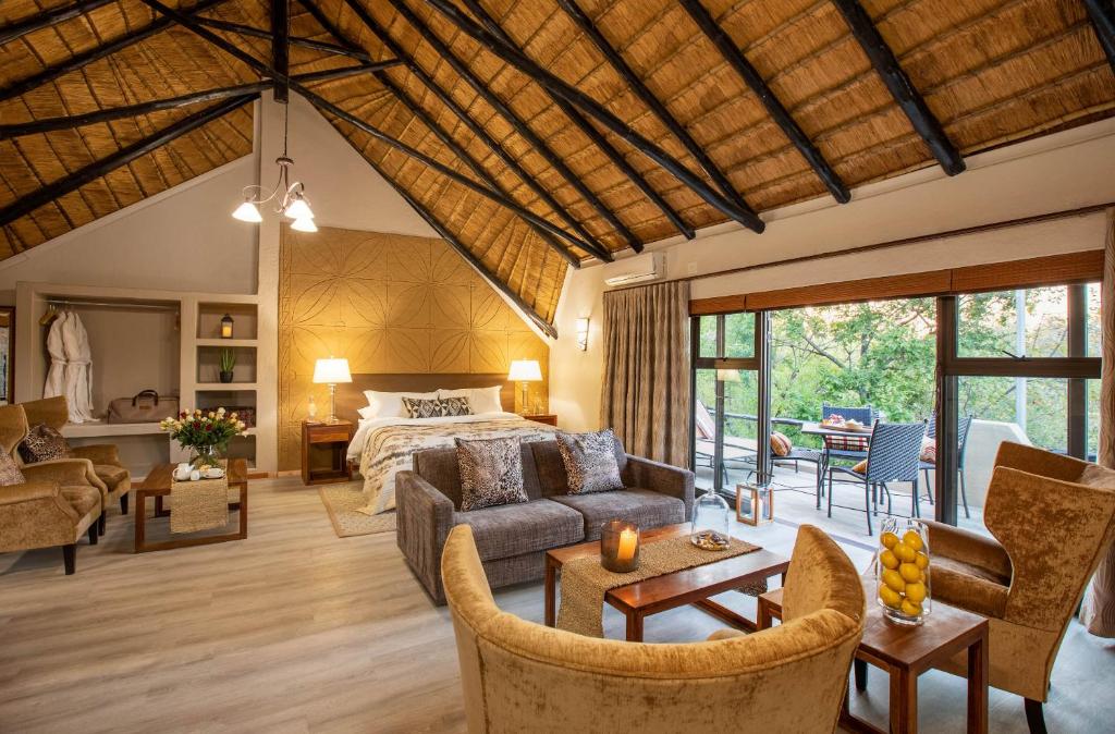 a bedroom with a bed and a living room at Mabula Game Lodge in Mabula