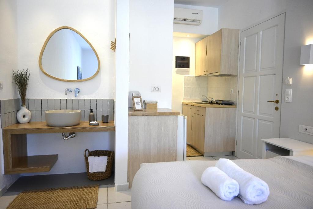 W łazience znajduje się łóżko, umywalka i lustro. w obiekcie Marika Studios & Apartments w mieście Georgioupolis