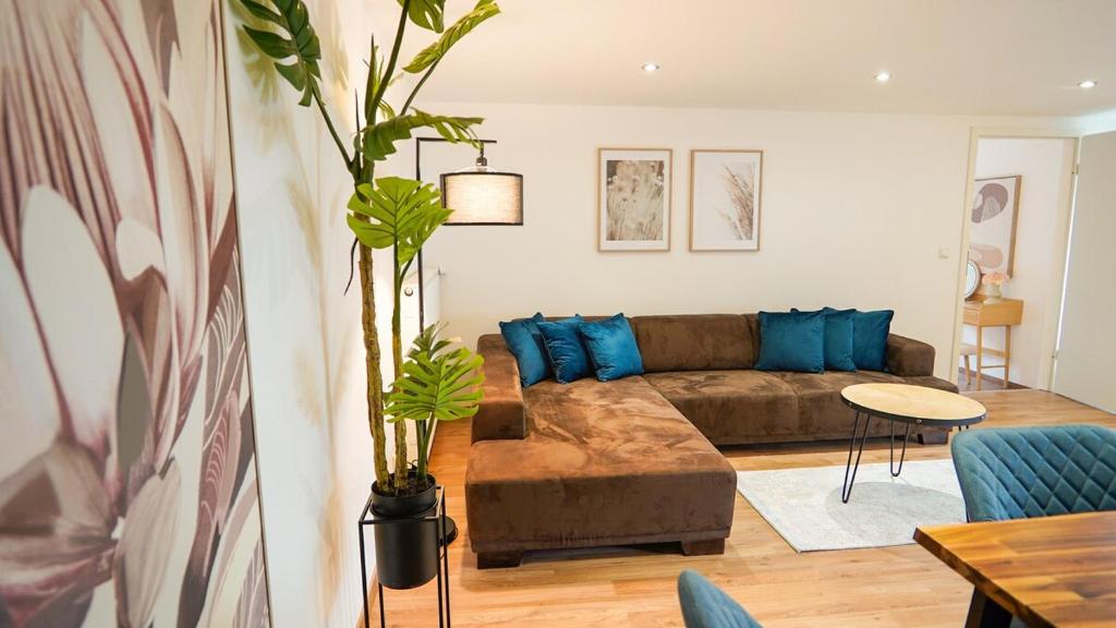 a living room with a brown couch and blue pillows at Papyrer Apartment - Stilvolles Apartment in Lenggries in Lenggries