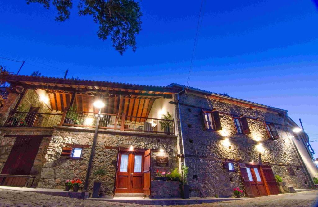 un antiguo edificio de piedra con luces. en To Kastri en Kalopanayiotis