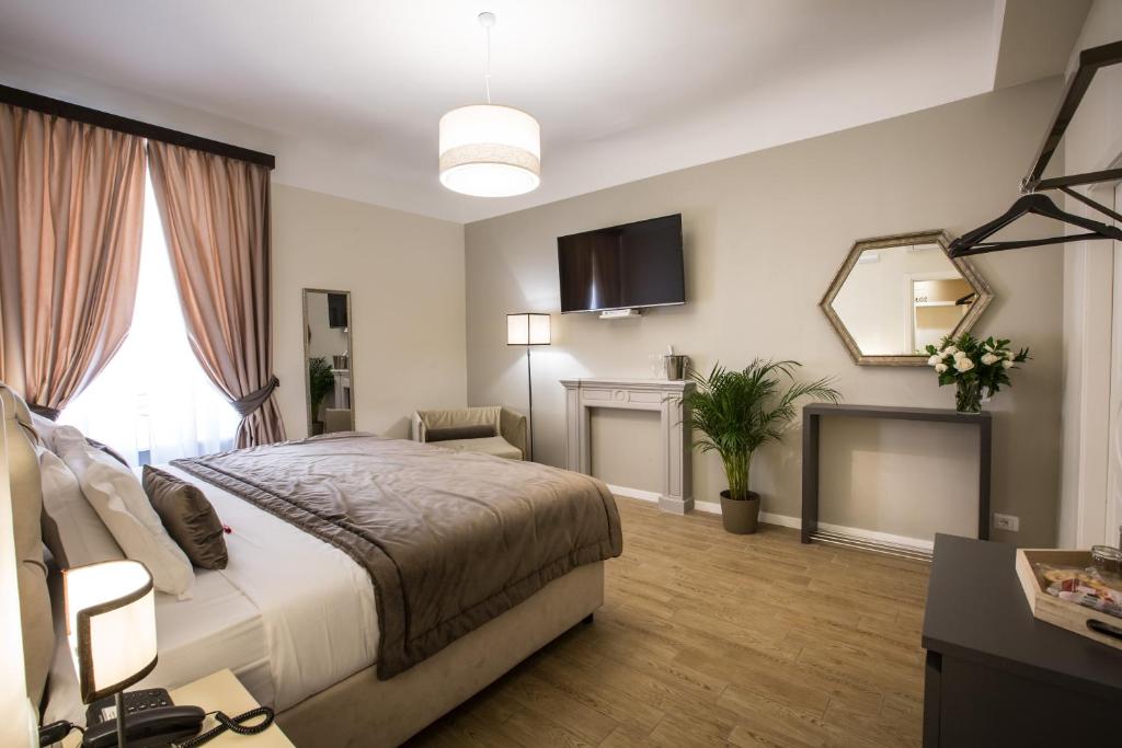 um quarto com uma cama grande e uma televisão em Chic & Town Luxury Rooms em Roma