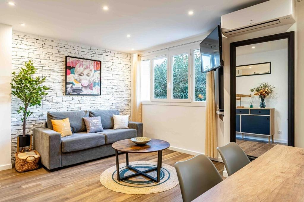 un salon avec un canapé et une table dans l'établissement Cassis le Marignan- rdc - garage - classé 3 étoiles, à Cassis