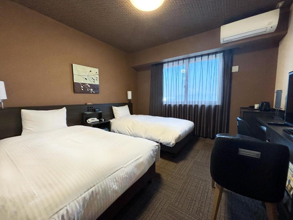 Postel nebo postele na pokoji v ubytování Hotel Route Inn Osaka Izumi -Kishiwada Izumi Inter-