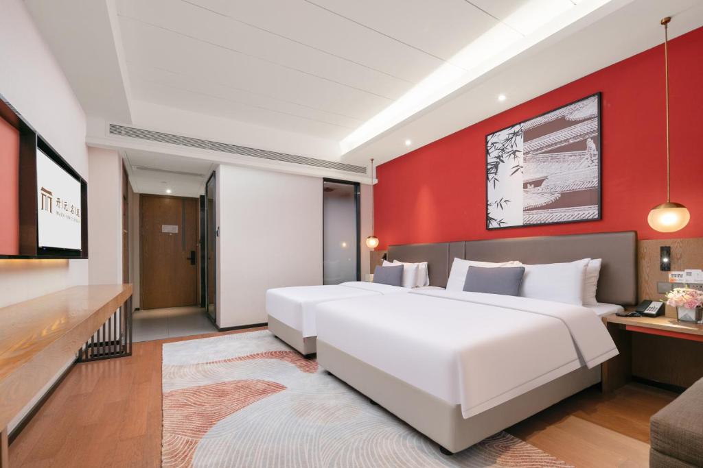 Postel nebo postele na pokoji v ubytování Mansion New Century Hotel Chengdu Wuhou