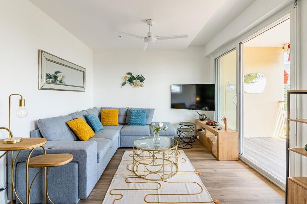 un soggiorno con un divano blu e una TV di Panoramic vue cassis a Cassis