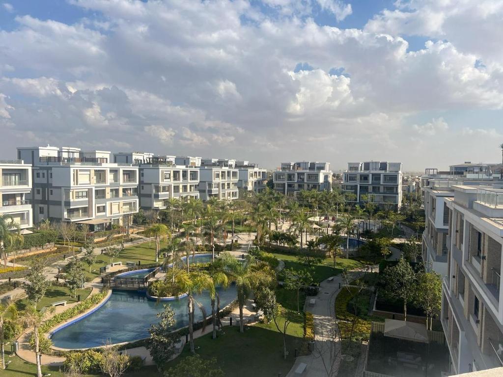 an apartment complex with a pool and palm trees and buildings at Studio beverly hills premium sheikh Zayed in Sheikh Zayed