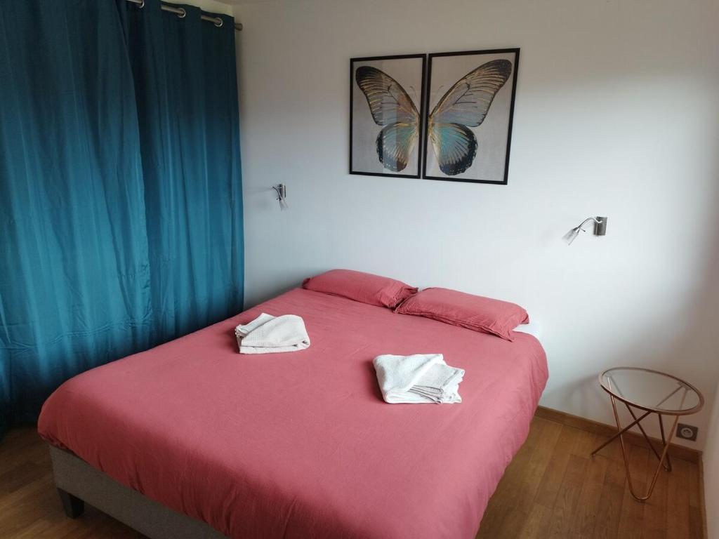ein Schlafzimmer mit einem rosa Bett mit zwei Handtüchern darauf in der Unterkunft Maison ecologique avec jardin in Elne