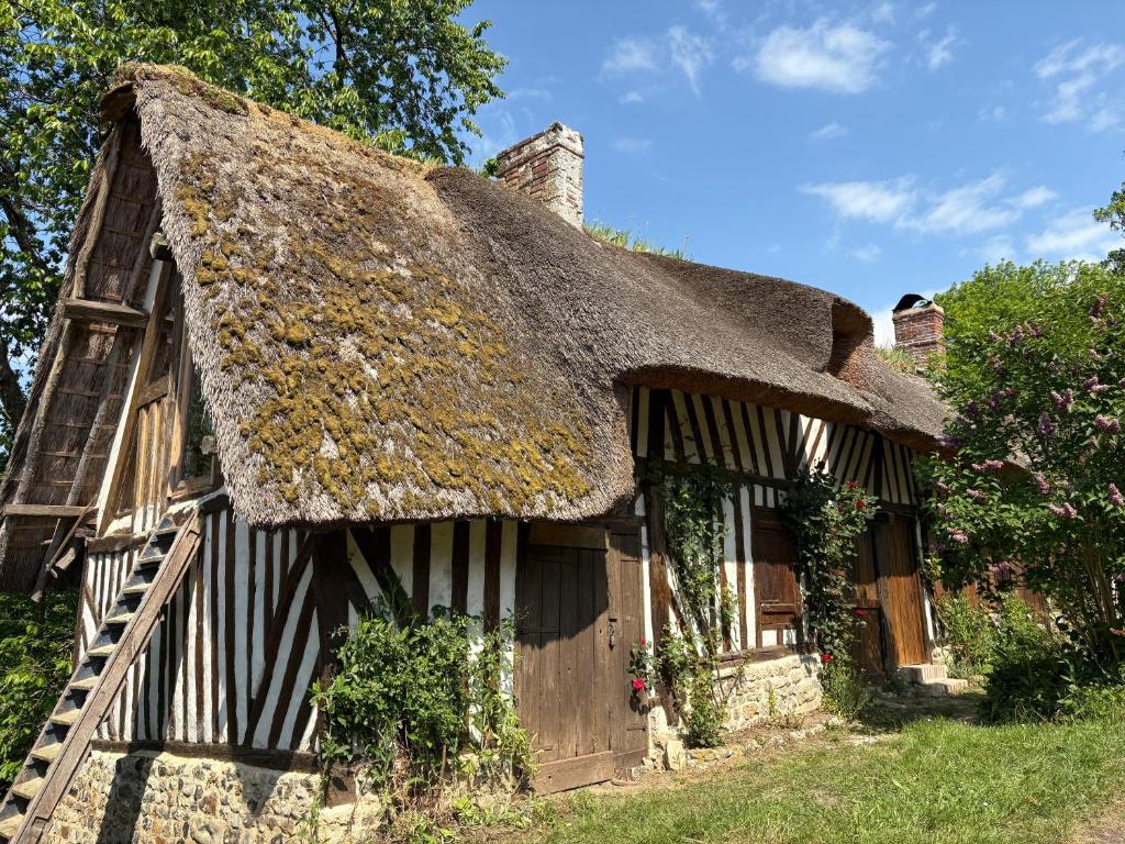 Ce cottage ancien au toit de chaume comprend : dans l'établissement Chaumière d'écrivain au cœur de la Normandie, à Fiquefleur-Équainville