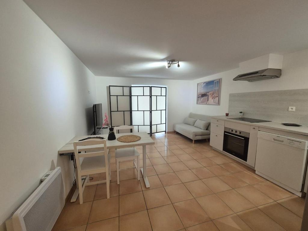 une cuisine et un salon avec une table et un canapé dans l'établissement Grand Studio à Deux Pas de la Mer La Ciotat, à La Ciotat