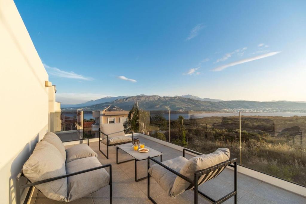 a balcony with chairs and a table and a view at Jarko Luxury Houses in Argoulidhés