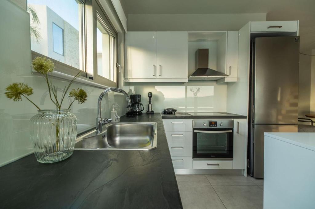 a kitchen with a sink and a stainless steel refrigerator at Jarko Luxury Houses in Argoulidhés