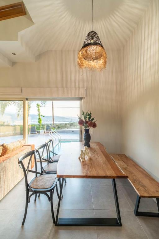 a dining room with a wooden table and chairs at Jarko Luxury Houses in Argoulidhés