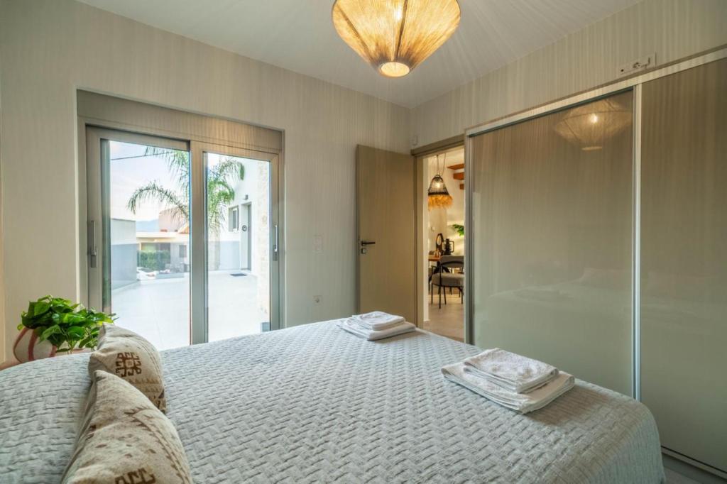 a bedroom with a bed with two towels on it at Jarko Luxury Houses in Argoulidhés