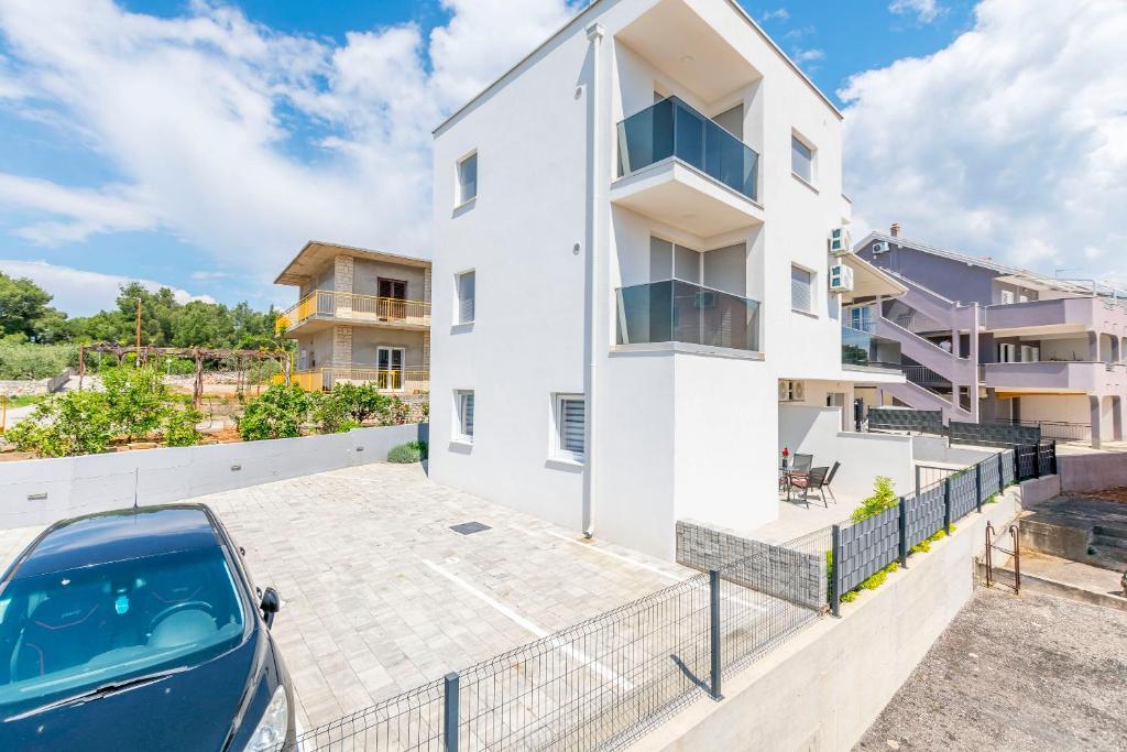 a car parked in a parking lot in front of a building at Apartments Tonka in Primošten