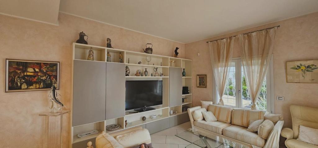 salon z kanapą i telewizorem w obiekcie L'azura Villa Front De Mer Golf Juan w mieście Vallauris