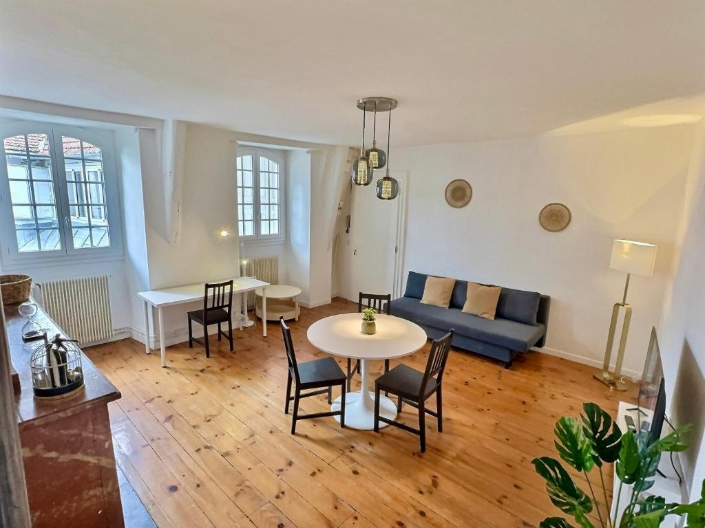 un salon avec un canapé, une table et des chaises dans l'établissement WonderHost, une entrée Historique sur la Ville, à Pau
