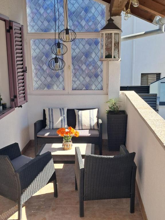 a patio with chairs and a table and some windows at 1918Apartman Šibenik centar,Poljana in Šibenik