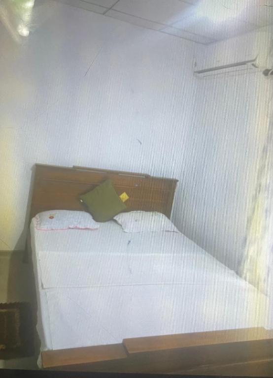 1 cama blanca pequeña en una habitación pequeña en Nataliya, en Nikawatawana