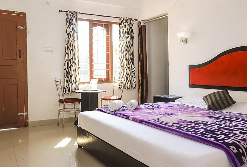 una camera da letto con un letto, un tavolo e una finestra di Glen Brook Cottage a Devikolam