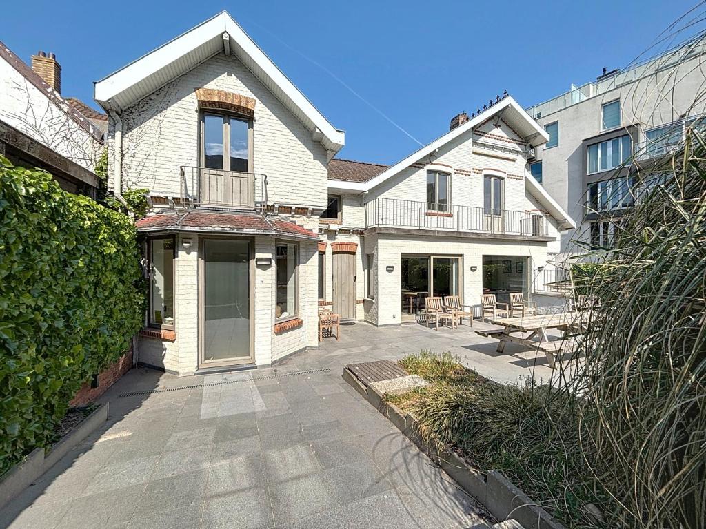 a large white house with a patio in front of it at ons kotje in De Panne