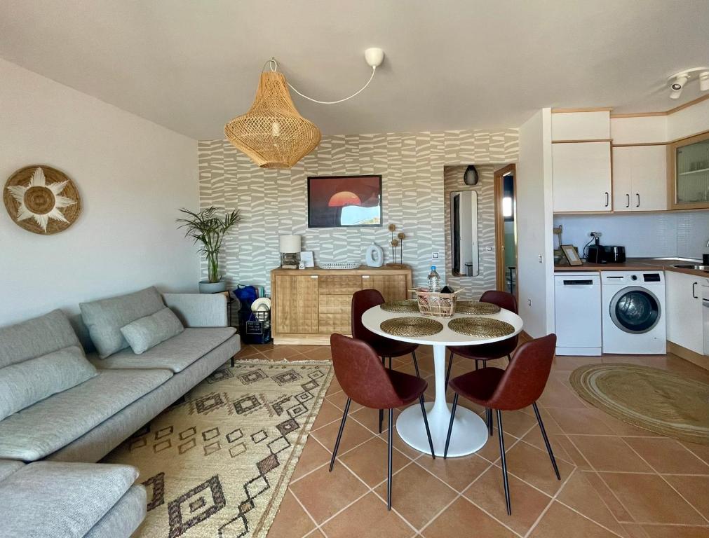 ein Wohnzimmer mit Sofa und Tisch in der Unterkunft THE PLACE - surf & soul in Majanicho