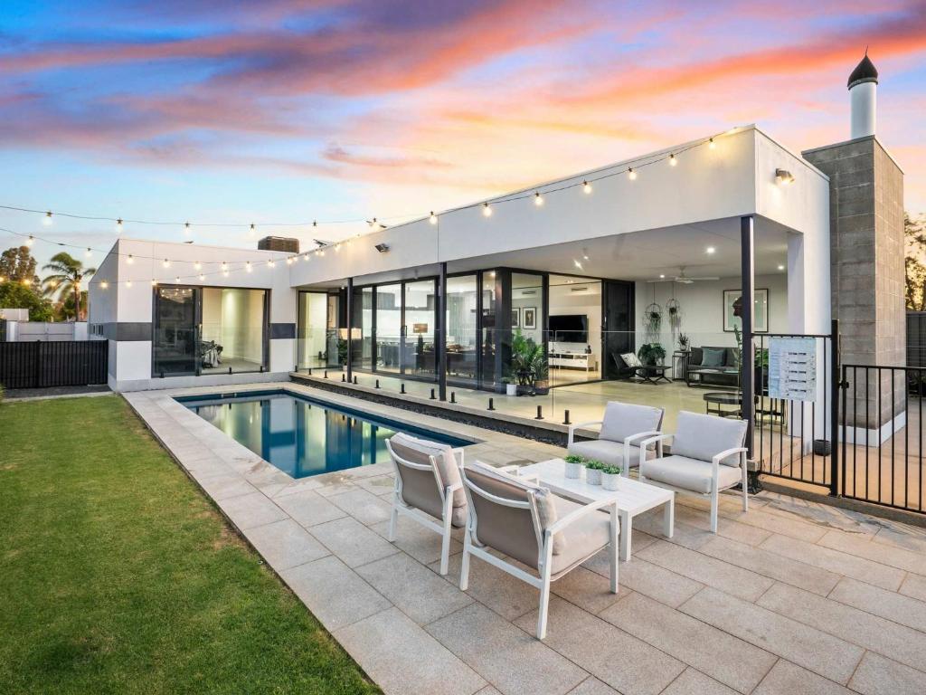 a house with a swimming pool and a patio at The Sinatra Holiday House in Mulwala - 10 individual beds in Mulwala