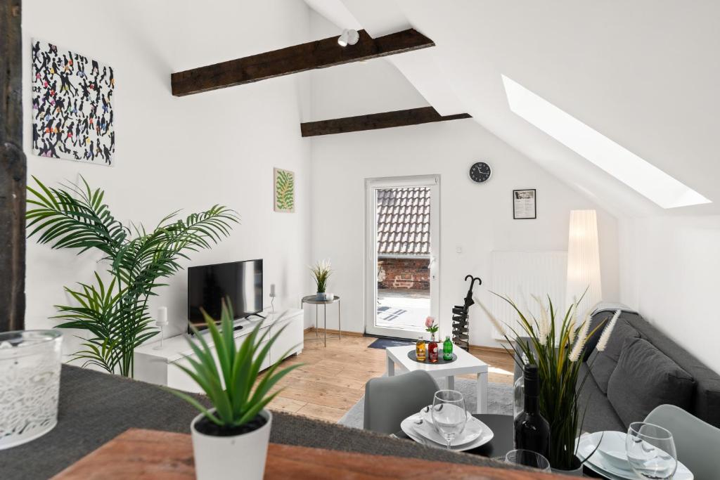 a living room with white walls and plants at MOLA Apartments-Charmante Ferienwohnung im Herdecke Zentrum für 3 Personen-große Dachterrasse-Grill-Gratis Parken-WLAN in Herdecke