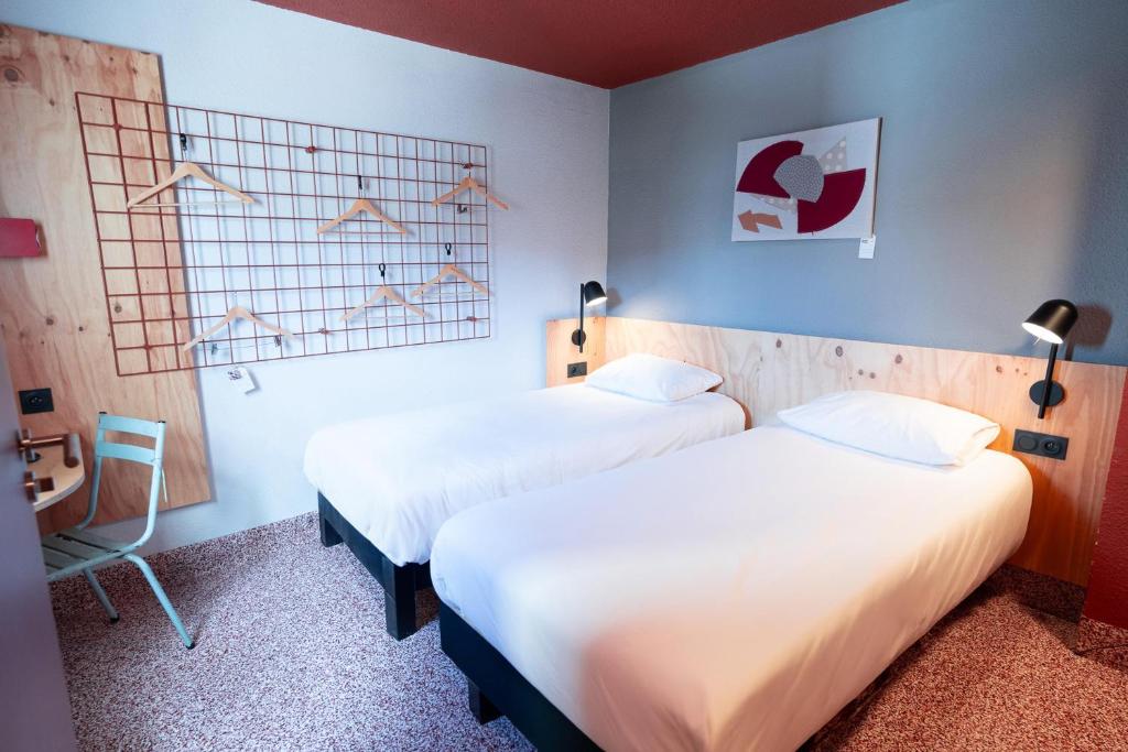 une chambre d'hôtel avec deux lits et une chaise dans l'établissement Greet hôtel Montpellier Aéroport Parc des Expos, à Mauguio