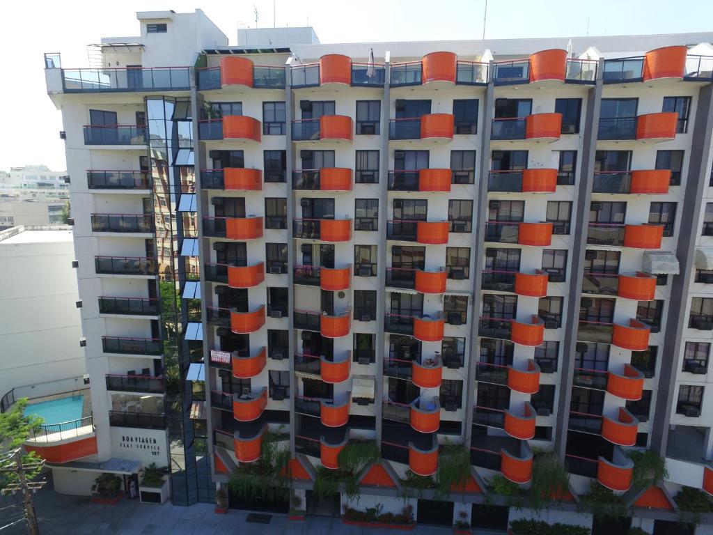 a tall apartment building with orange balconies on it at Niteroi Flats in Niterói