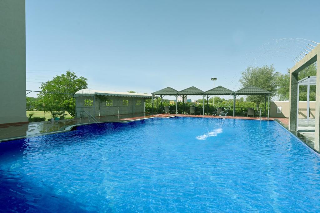 a large swimming pool with blue water at THE GANGA RESORT in Bikaner