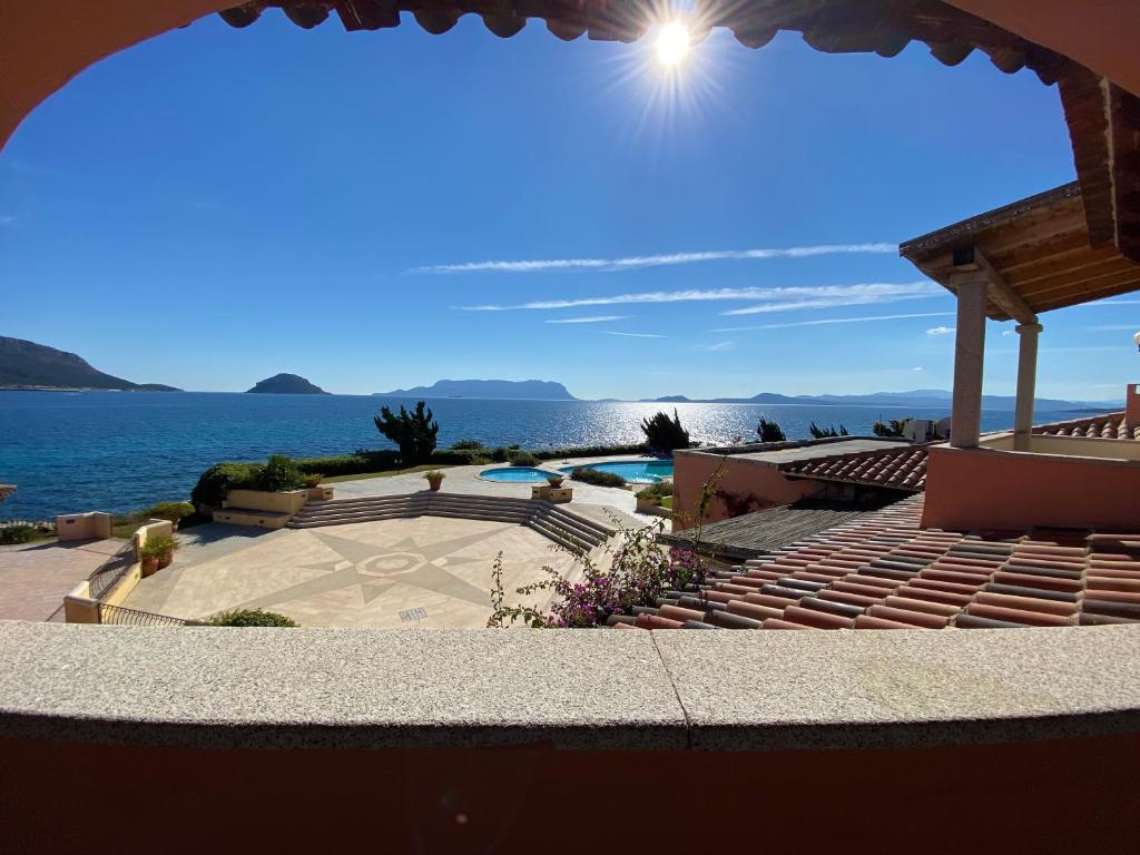 a view of a swimming pool and the ocean at Luxury apartment Ginepro sea view with common swimming pool just 50 mt from the beach in Golfo Aranci
