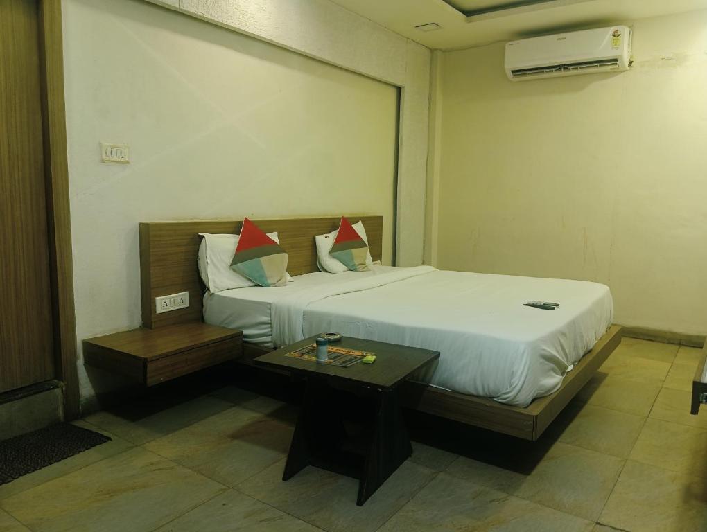 a hotel room with a bed and a table at Hotels SVL in Indore