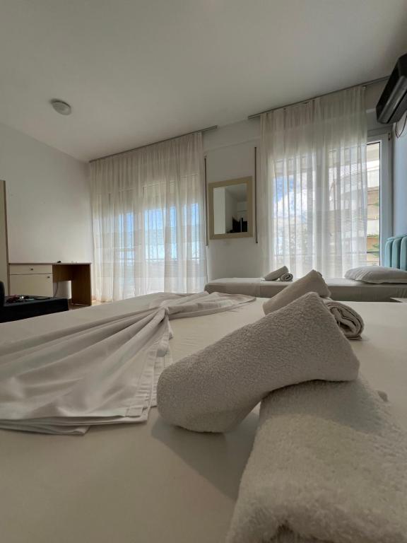 a bedroom with white towels on a bed at The Blue Horizon in Vlorë