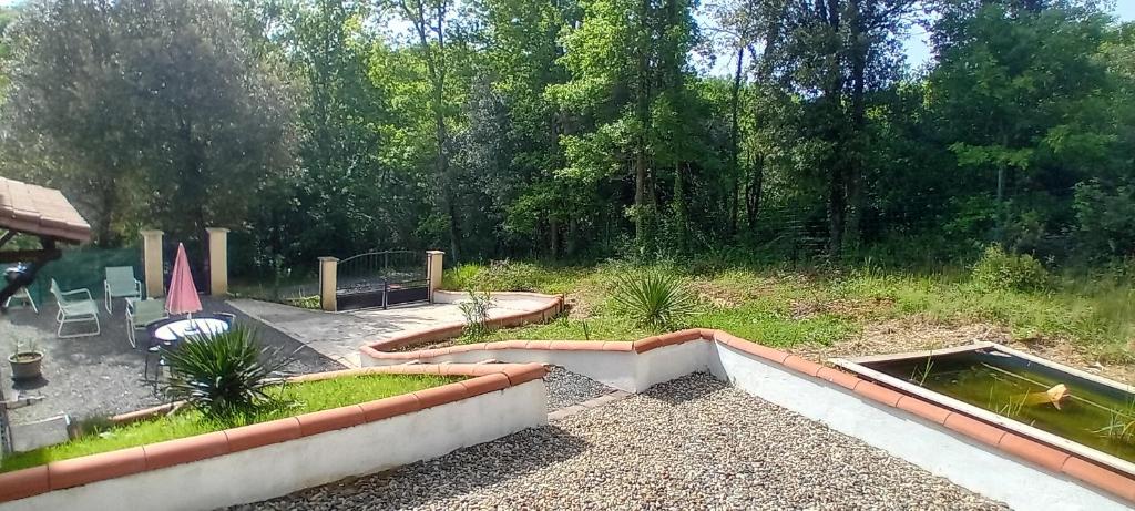 ein Hinterhof mit einem Teich und einem Teich in der Unterkunft Location 4 personnes avec jardin in Carsac-Aillac