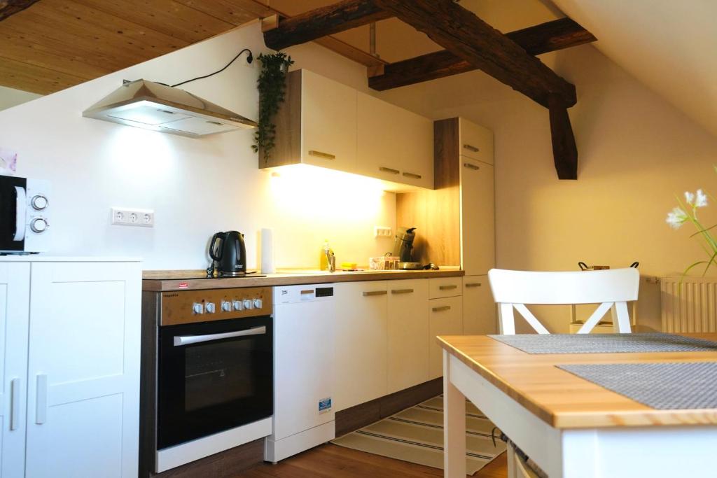 a kitchen with white appliances and a wooden table at Altstadt Apartment V- Studio-3 Personen- Waschmaschine- Parkplatz in Wolfsburg