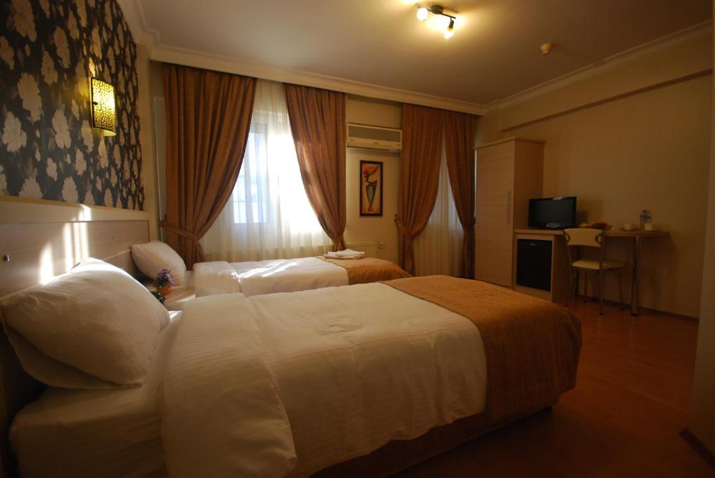 イズミールにあるミニ ホテルのベッド2台と窓が備わるホテルルームです。