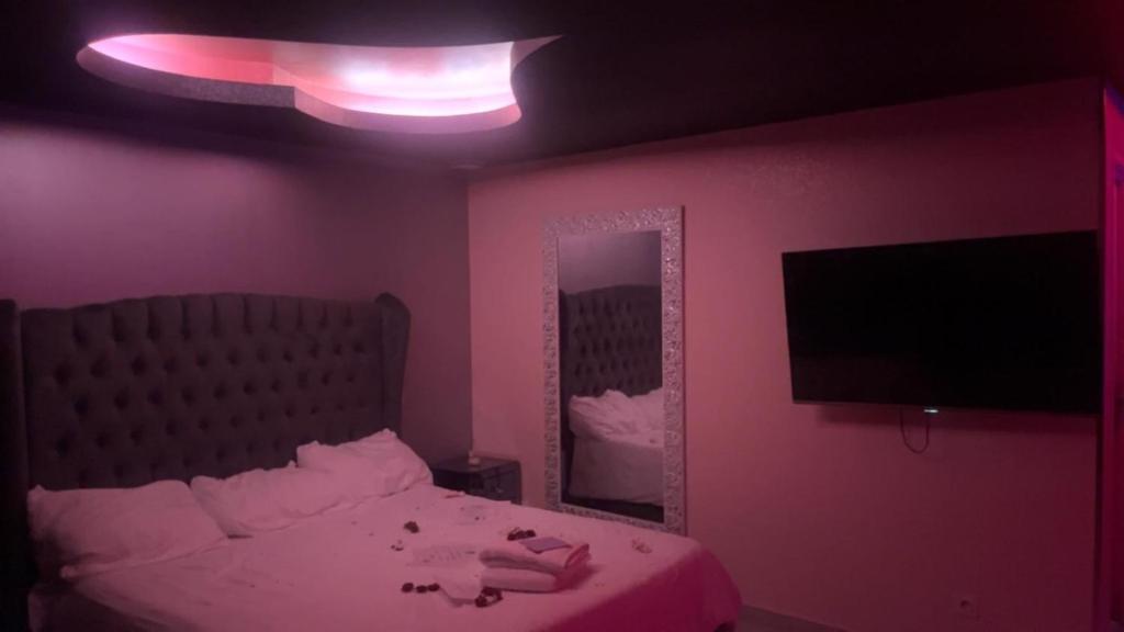 une chambre avec un lit et un grand miroir dans l'établissement Love Paradise, à Le Rove