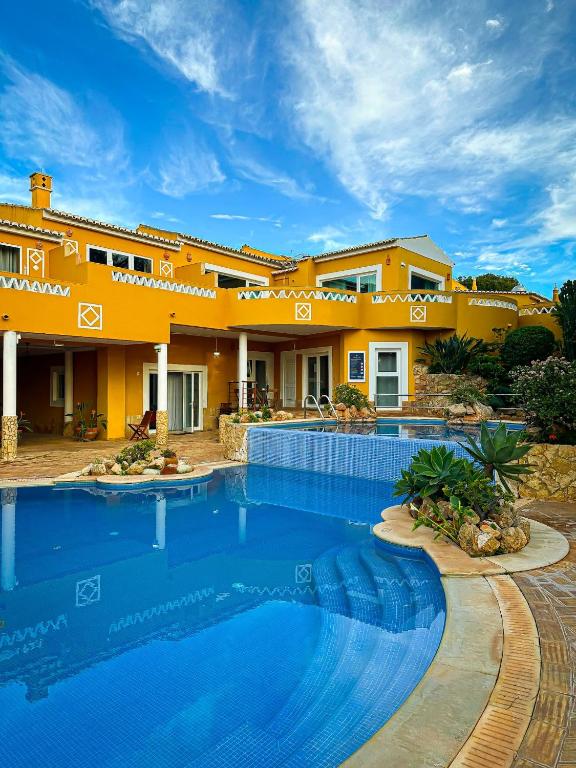 a house with a swimming pool in front of it at Montinho De Ouro in Luz