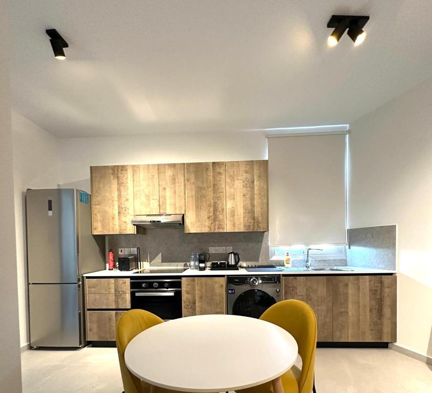 a kitchen with a table and a white table and chairs at Verasia Acute Stay in Engomi in Engomi